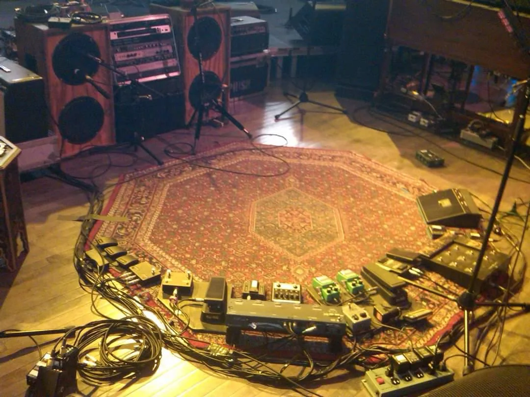 Trey Anastasio's Rocktagon rug on stage surrounded by his pedalboard and amplifiers